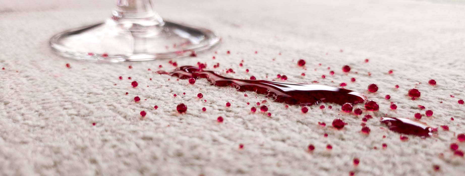 A picture of red wine spilling on an area rug protected with Fiber ProTector by Mafi.